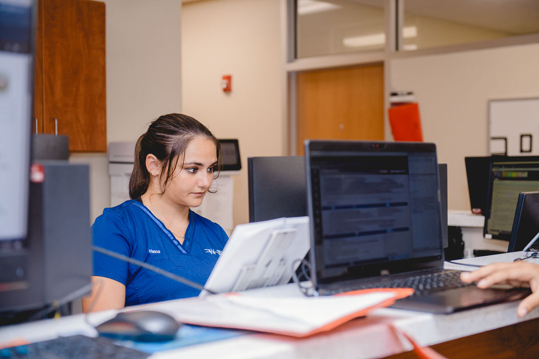 Natural workplace moment photographed at the front desk of a NYC healthcare office