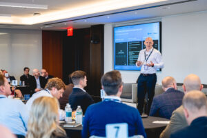 Corporate panel discussion with multiple speakers on stage at business conference in New York City